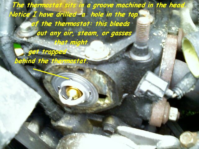The thermosrtat sits in a groove machined into the head. Notice that I have drilled a hole in the thermostat flange: this small hole will allow any air, steam, or gas to bleed past the thermostat.
